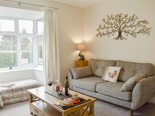 ein Wohnzimmer mit Sofa und Tisch in der Unterkunft Manor Park Cottage in Knitsley