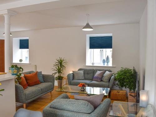 een woonkamer met twee banken en een tafel bij Turnstone Malthouse in Alnwick