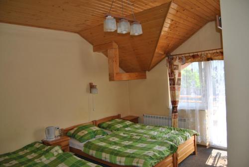 1 dormitorio con 2 camas y techo de madera en Willa pod Pilskiem, en Korbielów