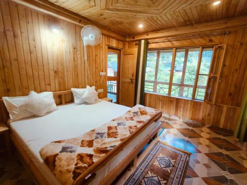 a bedroom with a bed in a wooden room at Tirthan Majestic View Homestay in Kulu