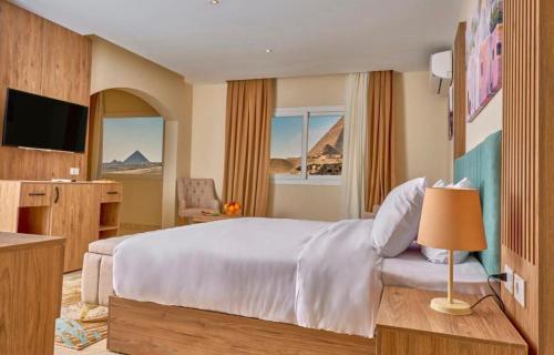 een hotelkamer met een bed en een televisie bij Lumora Pyramids InN in Caïro