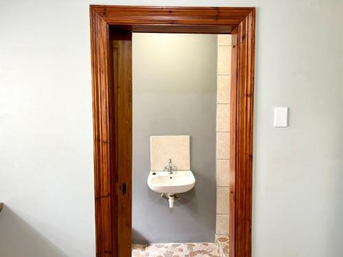 a bathroom with a sink and a mirror at Colline Sainté Cottage in Port Alfred