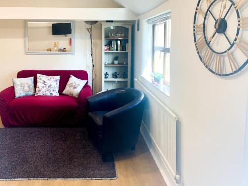 Saltfleetby Saint ClementにあるHorseshoeのリビングルーム(赤いソファ付)