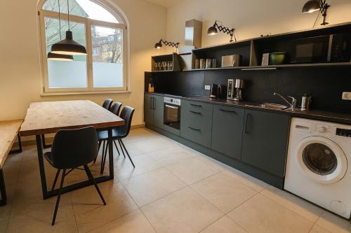 une cuisine avec une table et une machine à laver dans l'établissement YFB-170m2 Apartment für bis zu 15, modern, 1min zu UBahn, Ruhige Lage, Parkplätze, WIFI, Netflix, Kindergerecht, à Nuremberg