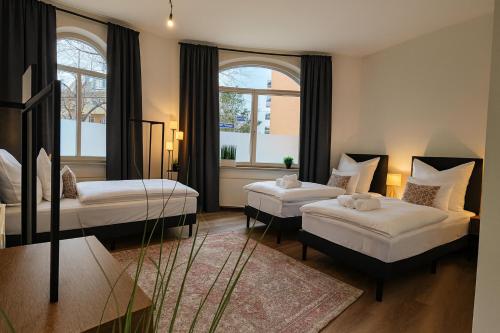 une chambre avec deux lits et deux fenêtres dans l'établissement YFB-170m2 Apartment für bis zu 15, modern, 1min zu UBahn, Ruhige Lage, Parkplätze, WIFI, Netflix, Kindergerecht, à Nuremberg