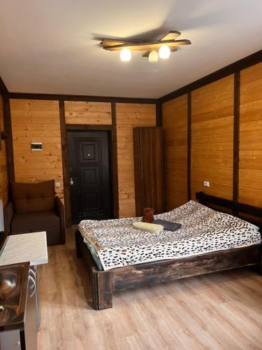 a bedroom with a bed with a teddy bear on it at SONATA Чан біля річки in Skole