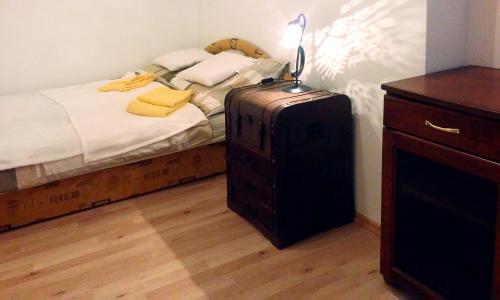 ブダペストにあるMo Apartmanのベッドルーム1室(ドレッサーの横にスーツケース付きのベッド1台付)