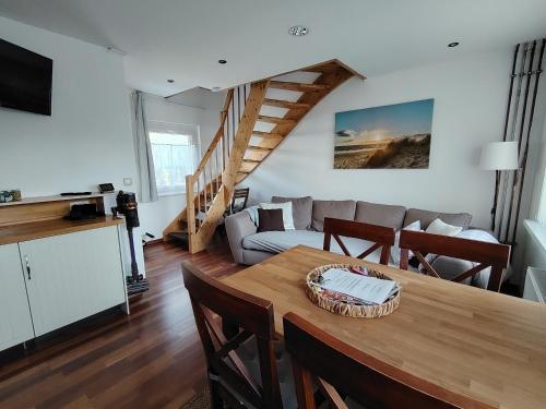 a living room with a table and a couch at Ferienhaus An der Brunnenaue in Stralsund