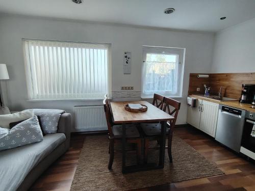 a living room with a table and a couch at Ferienhaus An der Brunnenaue in Stralsund