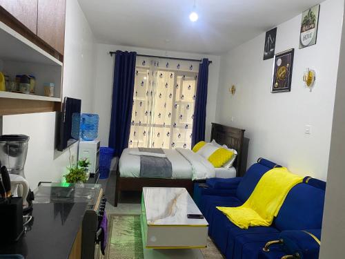 ein Wohnzimmer mit einem Bett und einer blauen Couch in der Unterkunft Tsavo Royal Suburb - blossom homes in Nairobi