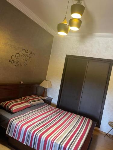 a bedroom with two beds with a striped blanket at Confort & Emplacement, Pieds dans l'eau in Mansouria
