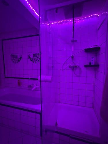 a bathroom with a tub and a purple light at Sky Harmony Penthouse mit Wasserbett, Jacuzzi und Grill in Villingen-Schwenningen