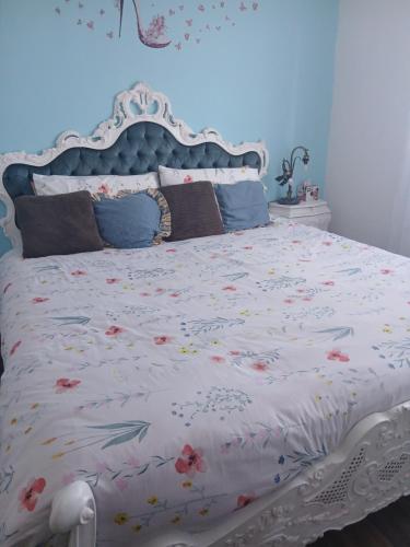 a bed with a white bedspread with flowers on it at Casa Aurora Nicole in Pergine Valsugana