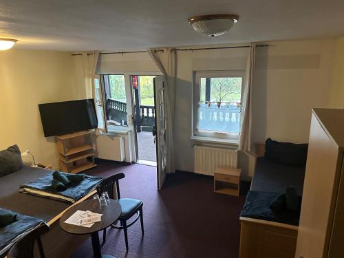 a living room with a couch and a tv at Motel Zur Festwiese in Gierstädt