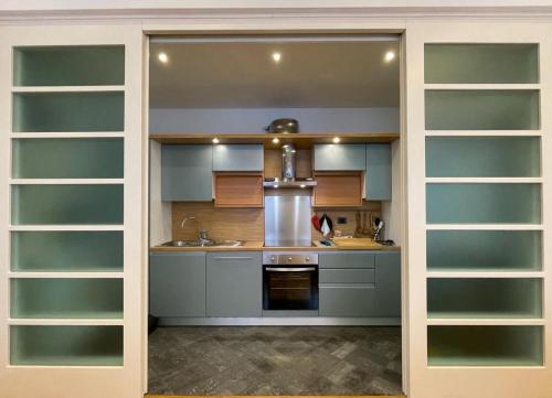 a kitchen with glass shelves and a sink and a stove at A Casa di Ale in Gubbio