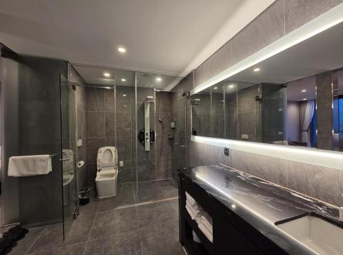 a bathroom with a shower and a toilet and a sink at Nova Stay Gangneung in Chumunjin