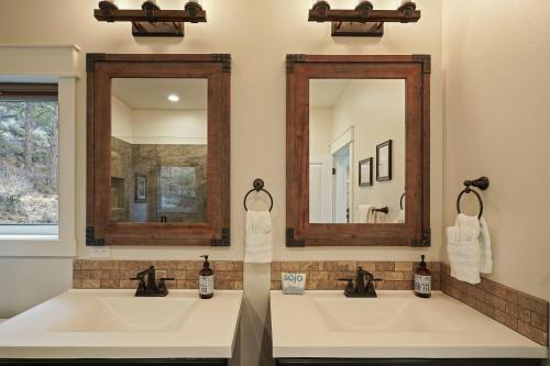 two sinks in a bathroom with two mirrors at Trails End Retreat in Bend