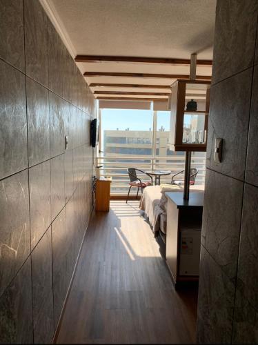 a room with a bed and a table and a window at Pingel Apartment Vista Mar in Viña del Mar