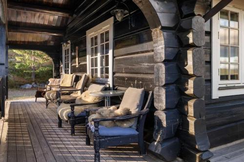 a row of chairs and tables on the porch of a building at Trysilfjell 615 by Vacation Trysil in Hovi