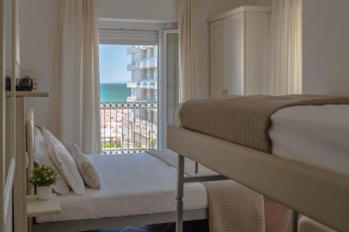 a bedroom with a bed and a view of the ocean at Hotel Philadelphia in Cattolica