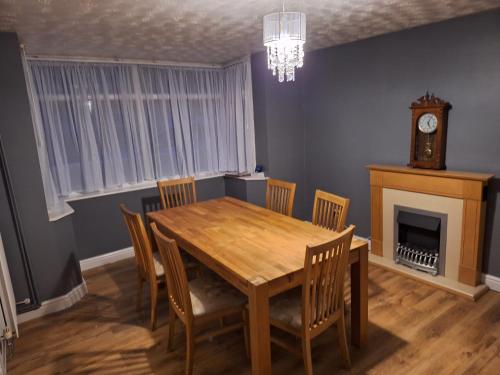 ein Esszimmer mit Tisch und Stühlen und einer Uhr in der Unterkunft Pearl Beach House, Lincs in Mablethorpe