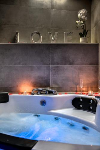 una vasca da bagno in un bagno con un cartello sul muro di Le bourget - Suite romantique a Narbonne
