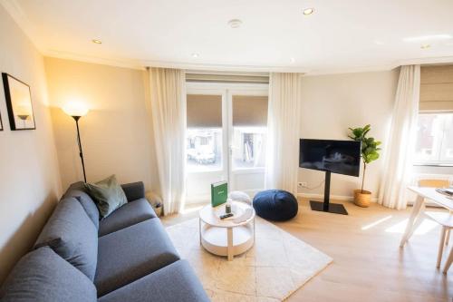 a living room with a blue couch and a tv at Prestige 70m2 Two-Bedroom Apartment - VW142A in Eindhoven