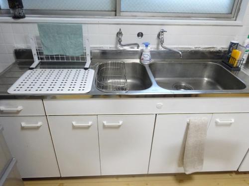 a kitchen sink with a dish drying rack next to it at 豊橋南栄駅徒歩1分 最大9名一棟貸 ホタルヤ Guest House Hotaruya Toyohashi Minami Sakae in Toyohashi