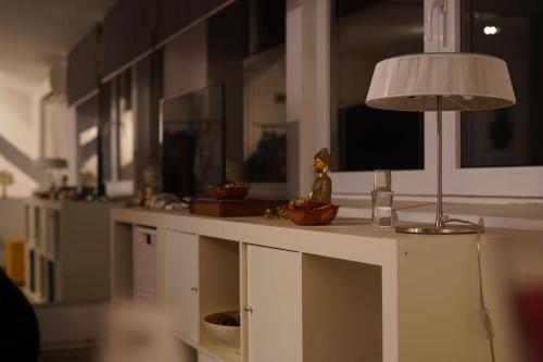 une table avec une lampe au-dessus dans l'établissement Bucharest Residence, à Bucarest