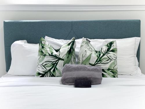 a bed with white pillows and a green headboard at Bright and chic home with a cozy touch in Windsor