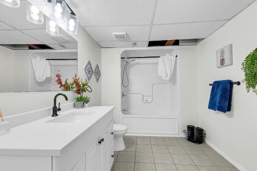 a white bathroom with a sink and a toilet at Bright and chic home with a cozy touch in Windsor