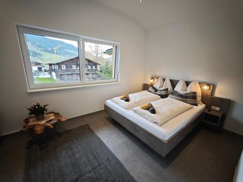 a bedroom with a bed and a large window at HausTipTop in Flachau