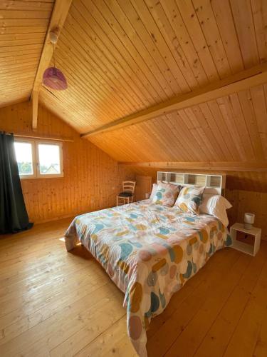 a bed in a room with a wooden ceiling at Au petit Suquet in Andregeat