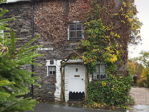ein altes Steinhaus mit einer weißen Tür in der Unterkunft Hayrake in Ambleside