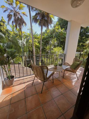 a patio with two chairs and a table on a balcony at Beach-Apartments Close to Town in Port Douglas