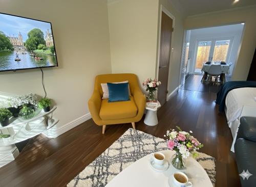 a living room with a yellow chair and a tv at Walk to Addenbrookes - Stylish 1 bed Apartment in CBG