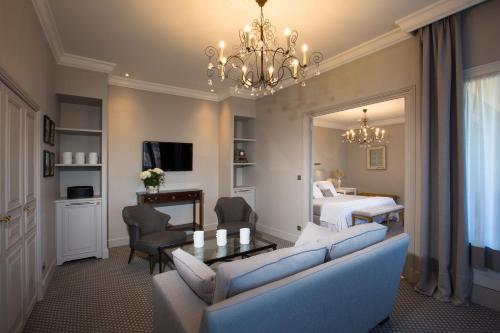 een woonkamer met een bank en een slaapkamer bij Hotel d'Europe in Avignon