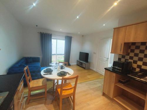a kitchen and a living room with a table and chairs at Connell Court in London