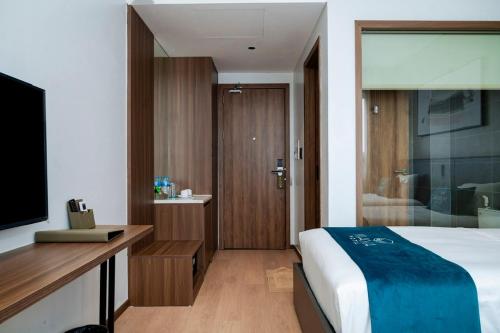 a hotel room with a bed and a television at Maya Hotel in Bản Giang