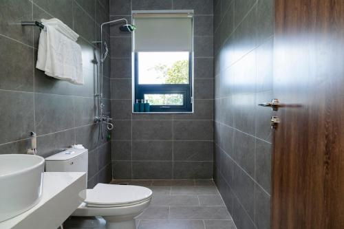a bathroom with a toilet and a sink and a window at Maya Hotel in Bản Giang