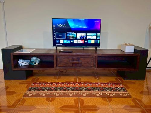 a tv sitting on top of a wooden entertainment center at inghome & guesthouse in Chiang Mai