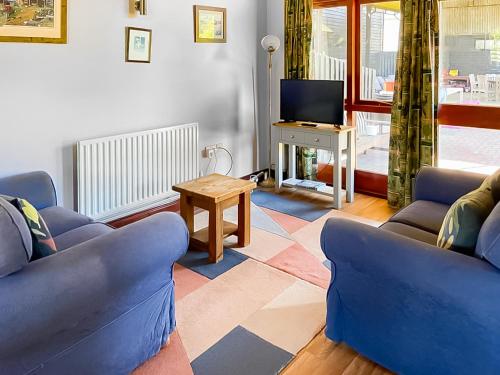 a living room with two blue couches and a tv at Swan in Welney