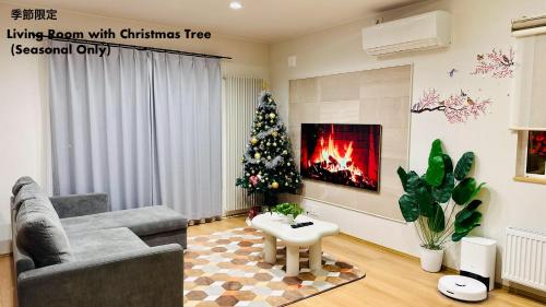 a living room with a christmas tree and a fireplace at Snow Sapporo Homestay in Sapporo