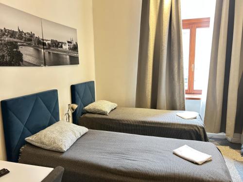 een kamer met twee bedden, een tafel en een raam bij CityGate Kraków in Krakau