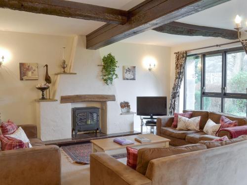 een woonkamer met twee banken en een open haard bij Dray Cottage in East Allington