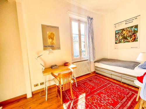 a bedroom with a desk and a bed and a window at Casa Tranquilla in Cannobio