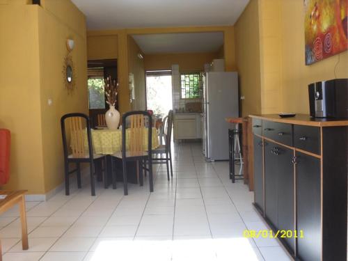 a kitchen and dining room with a table and a refrigerator at laréunion in Maison Henou