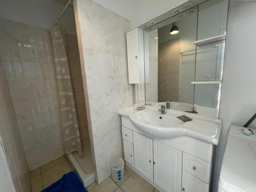 a white bathroom with a sink and a shower at Casa Marie in Sampolo