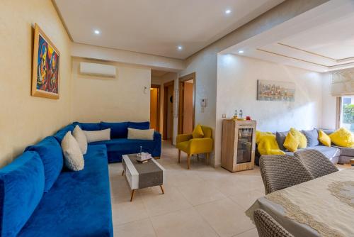 a living room with a blue couch and yellow pillows at Spacious luxury apartment with pool in Bouznika
