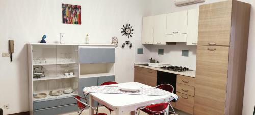 a small white kitchen with a table and chairs at L'approdo in Schisò